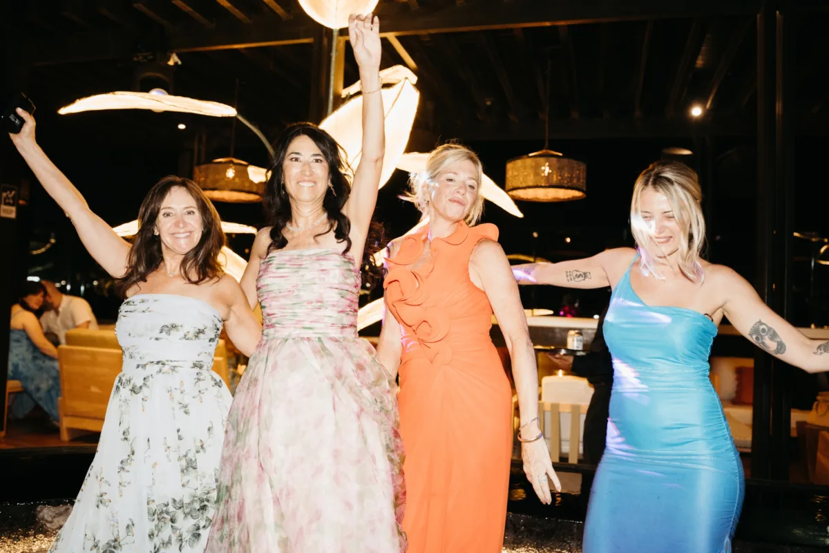 cabo destination wedding dancing engaging events by ali chicago wedding planner - Luxury Cabo Wedding at The Cape, a Thompson Hotel Four women in colorful dresses dancing and celebrating at luxury Cabo destination wedding at The Cape Thompson Hotel planned by Chicago wedding planner Engaging Events by Ali