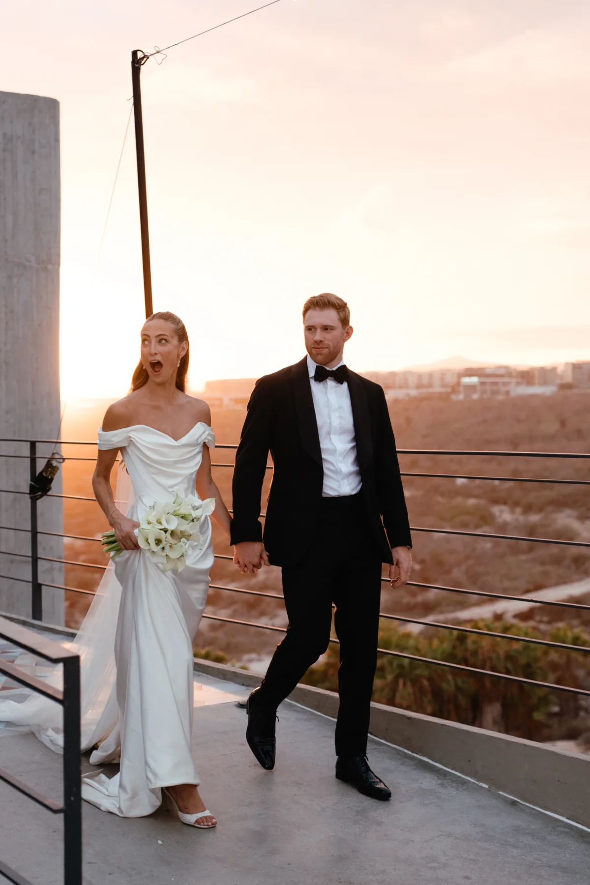 luxury cabo destination wedding planning engaging events by ali the cape thompson hotel 3 - Luxury Cabo Wedding at The Cape, a Thompson Hotel Newlyweds walking hand in hand during golden hour at luxury Cabo destination wedding at The Cape, a Thompson Hotel, planned by Engaging Events by Ali with white bridal bouquet by Aria Vera Floral