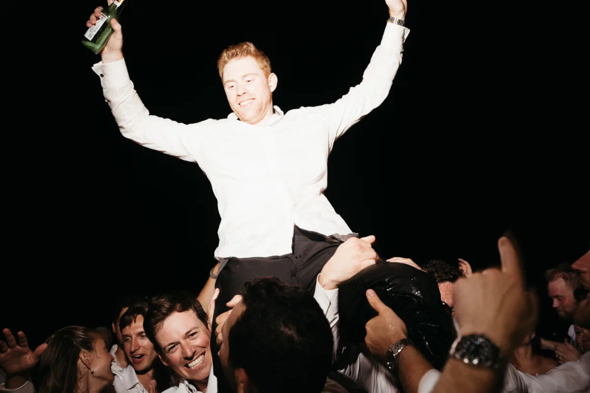 luxury cabo destination wedding reception celebration engaging events ali - Luxury Cabo Wedding at The Cape, a Thompson Hotel Groom celebrates being lifted by wedding guests at luxury Cabo destination wedding reception at The Cape Thompson Hotel planned by Engaging Events by Ali