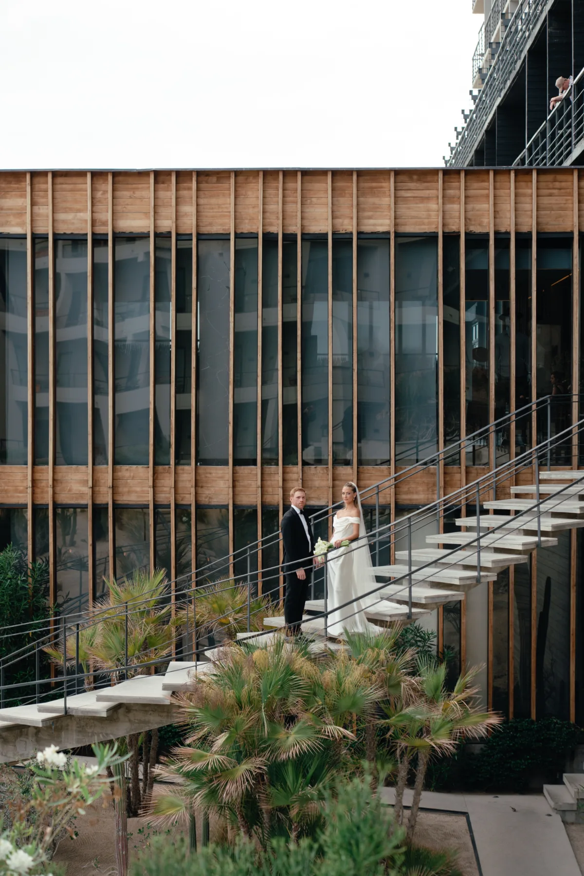 luxury cabo wedding planning the cape thompson hotel modern architecture - Luxury Cabo Wedding at The Cape, a Thompson Hotel Luxury Cabo wedding couple on modern staircase at The Cape Thompson Hotel with contemporary wood and glass architecture