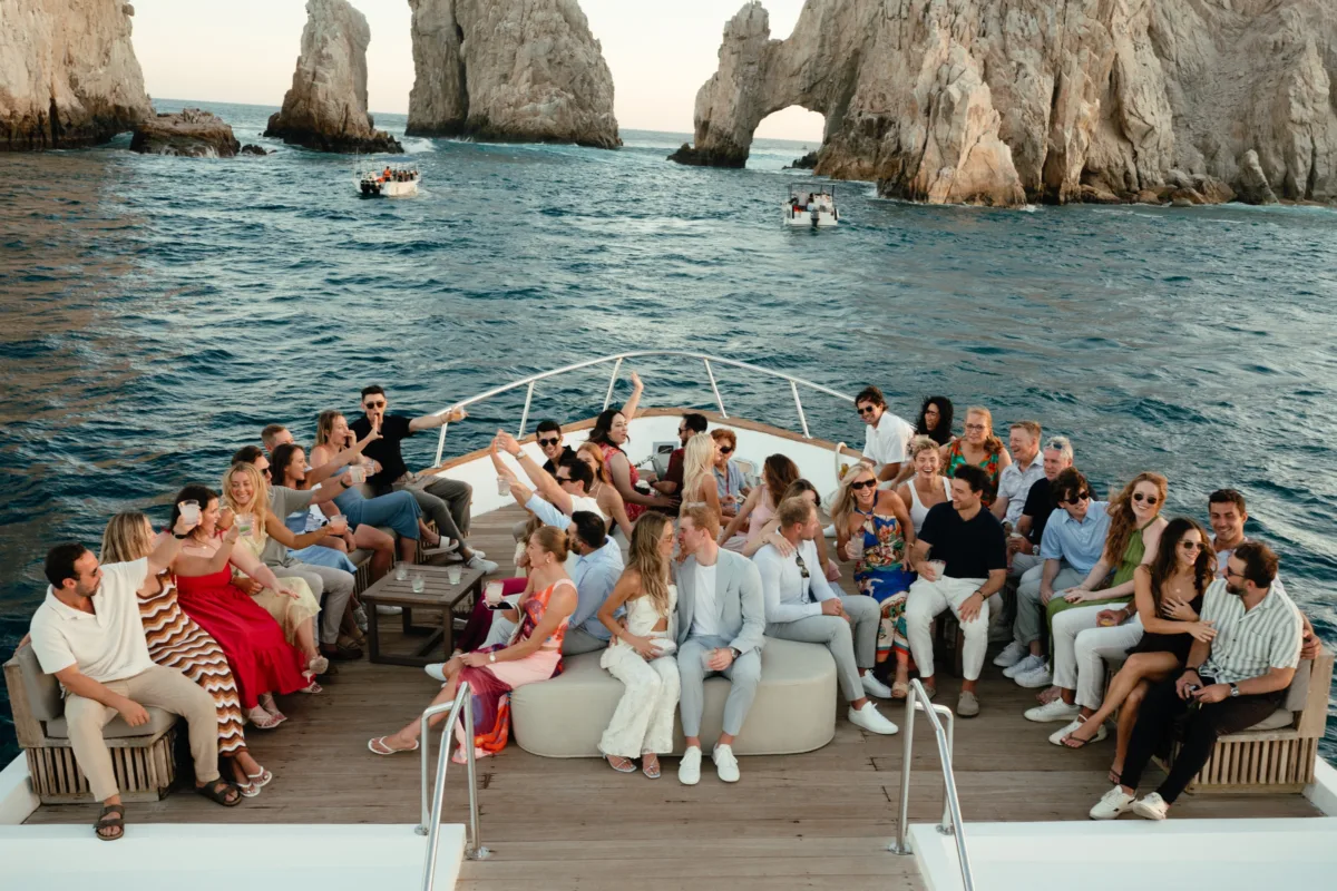luxury destination wedding boat party cabo san lucas engaging events ali - Luxury Cabo Wedding at The Cape, a Thompson Hotel Luxury destination wedding boat party with guests celebrating on yacht near dramatic rock formations in Cabo San Lucas planned by Engaging Events by Ali