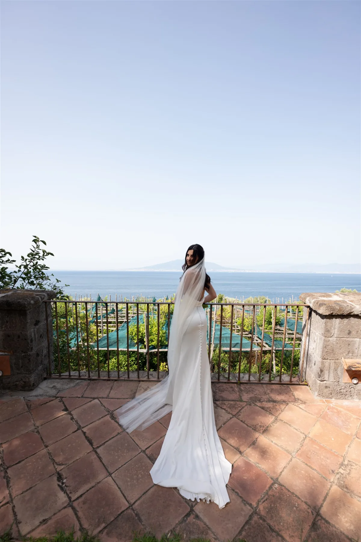 chicago wedding planner engaging events ali amalfi coast destination wedding capo santa fortunata sorrento - An Effortless Amalfi Coast Celebration Bride in flowing white gown overlooking Mediterranean coastline at Capo Santa Fortunata venue in Sorrento Italy planned by Chicago wedding planner Engaging Events by Ali