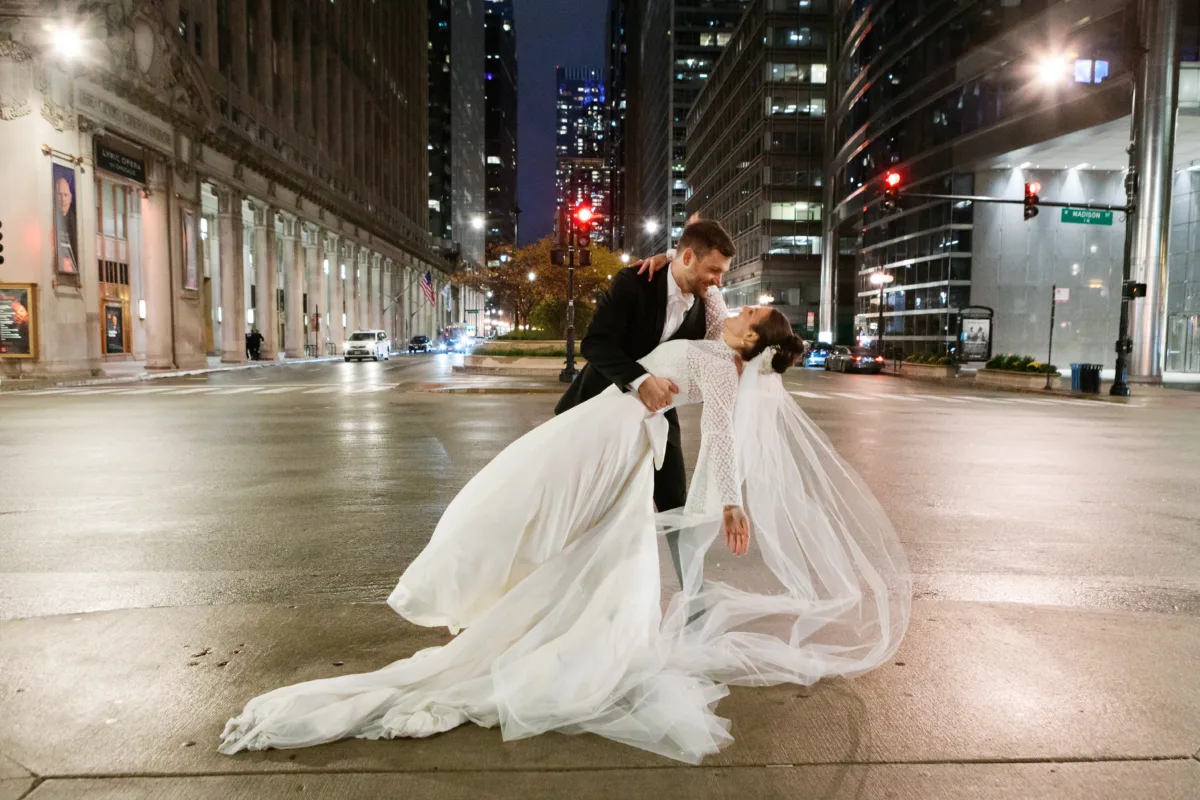 chicago wedding planning engaging events by ali downtown night portrait - A Golden Ritz-Carlton Chicago Celebration Bride and groom in romantic dip pose on downtown Chicago street at night with city lights, coordinated by wedding planner Engaging Events by Ali