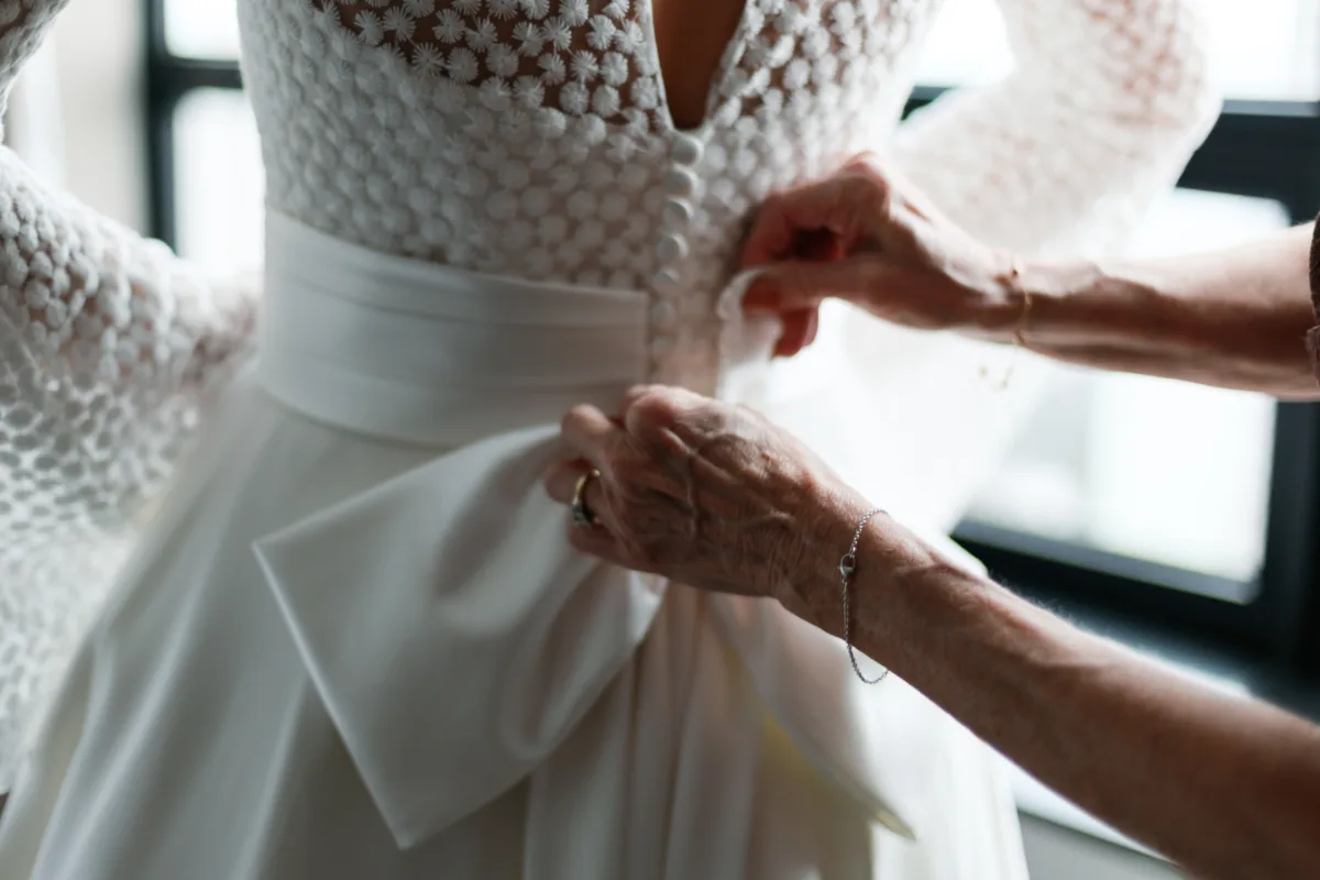 chicago wedding planning engaging events by ali ritz carlton bridal preparation - A Golden Ritz-Carlton Chicago Celebration Bride getting ready with wedding dress assistance at Ritz-Carlton Chicago celebration planned by Engaging Events by Ali