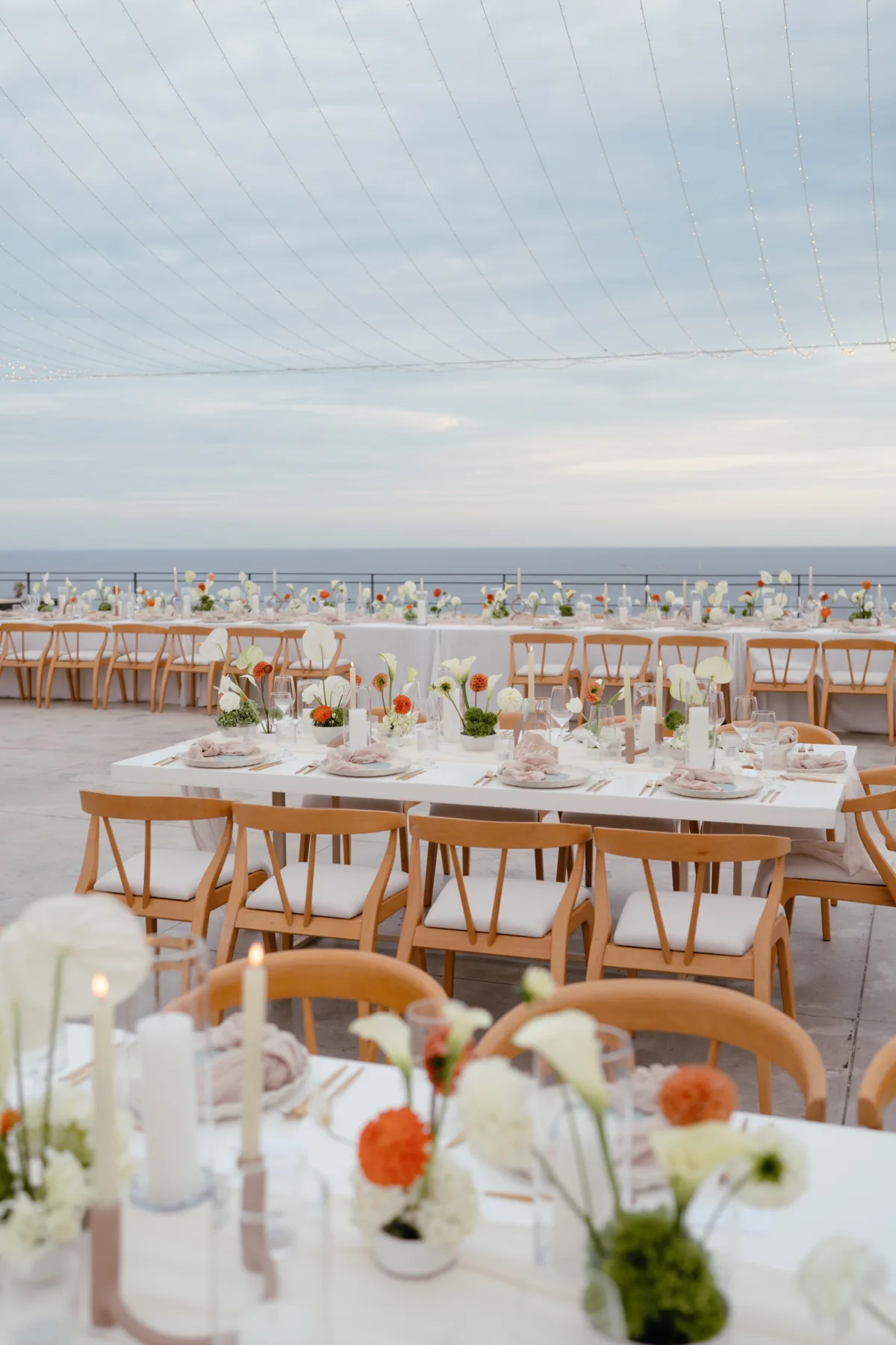luxury cabo destination wedding reception setup the cape thompson hotel - Luxury Cabo Wedding at The Cape, a Thompson Hotel Elegant oceanview wedding reception setup with wooden chairs and orange floral centerpieces at The Cape Thompson Hotel in Cabo planned by Chicago wedding planner Engaging Events by Ali