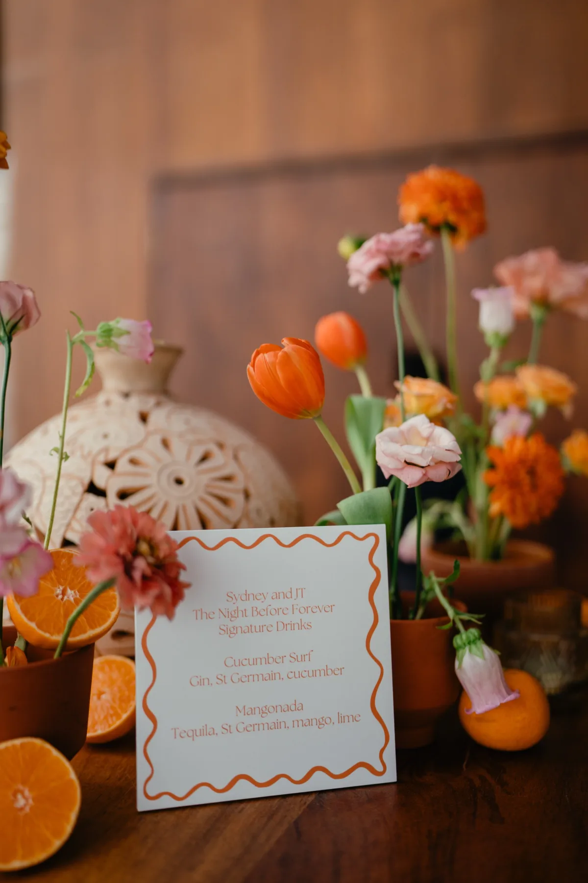luxury cabo wedding signature cocktail menu orange florals engaging events - Luxury Cabo Wedding at The Cape, a Thompson Hotel Luxury Cabo destination wedding signature cocktail menu with orange ranunculus florals and citrus decor at The Cape Thompson Hotel planned by Engaging Events by Ali