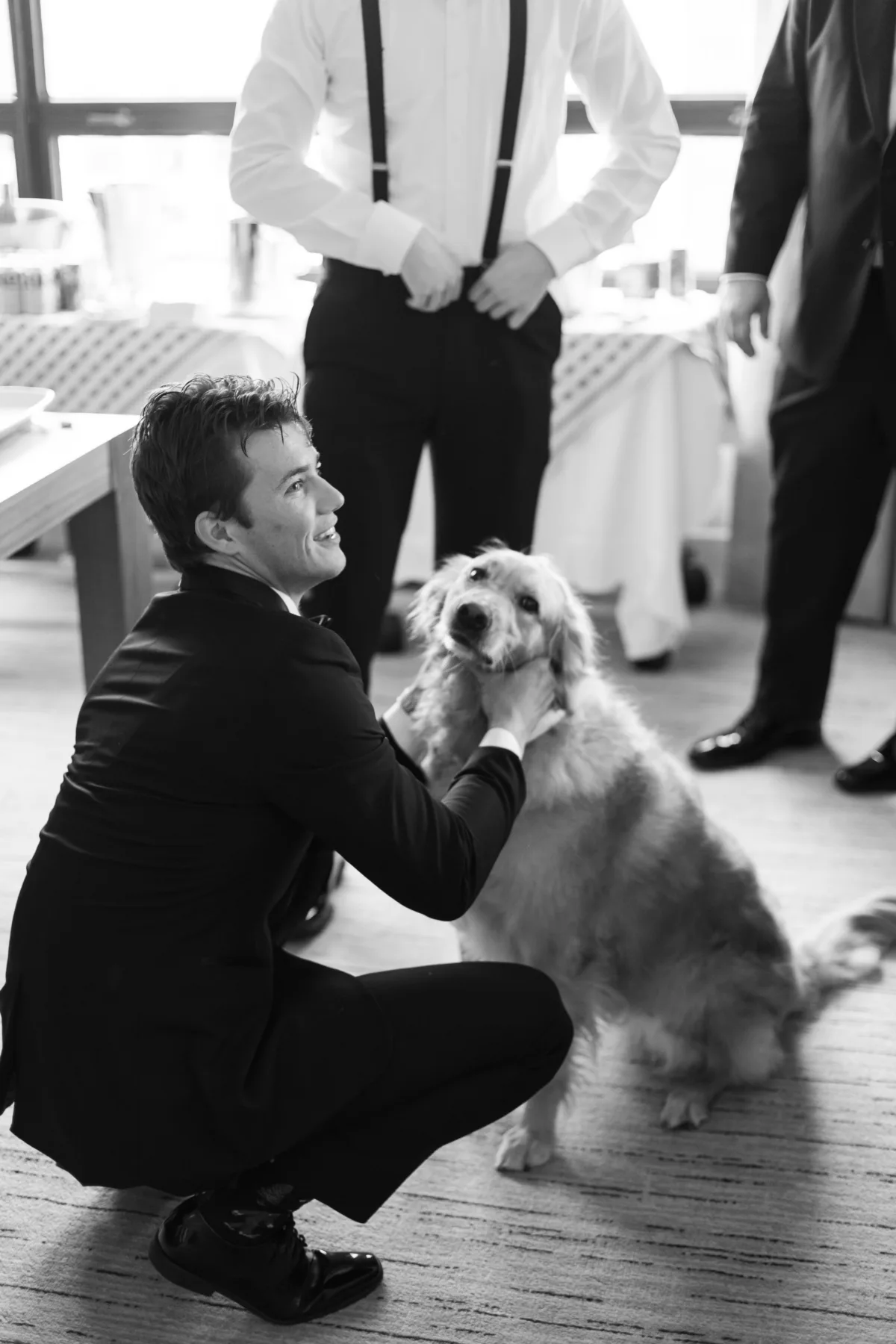 wedding planning groomsman with dog ritz carlton chicago engaging events by ali - A Golden Ritz-Carlton Chicago Celebration Groomsman in black suit kneeling with golden retriever dog during Ritz-Carlton Chicago wedding coordinated by Engaging Events by Ali